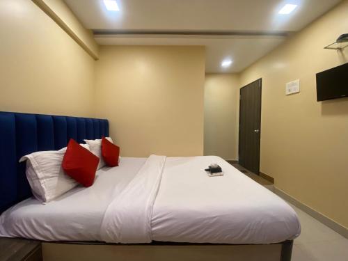 孟买Hotel Royal Grand - Near Mumbai International Airport的一间卧室配有一张带红色枕头的大床
