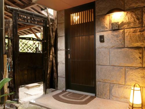 佐贺市Oyado Yumechidori的石墙房间的一扇开放式门
