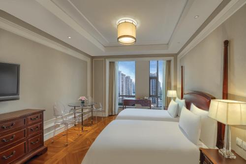 上海上海外滩浦华大酒店的一间卧室设有两张床和大窗户