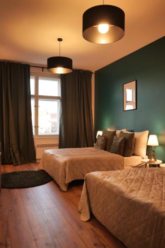布拉格Royal Square View Residence的卧室设有两张床铺和绿色的墙壁