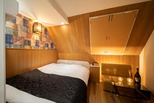 神户ホテル トランス 男塾ホテルグループ的一间带床和橱柜的小卧室
