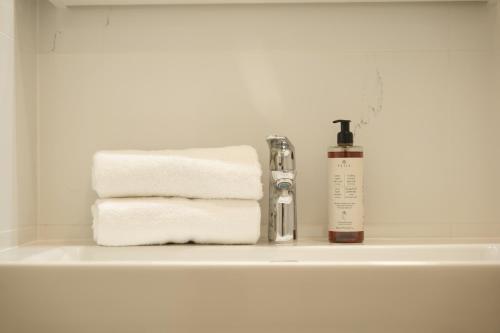 布拉格Royal Square View Residence的浴室水槽配有毛巾和1瓶肥皂