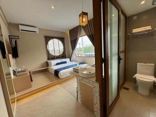 怡保Muzi Boutique Hotel的一间卧室设有一张床、一个卫生间和一个水槽