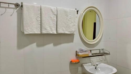 槟知雄王酒店 的浴室配有盥洗盆、镜子和毛巾