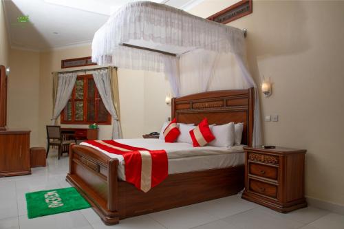 HoimaMiika Eco Resort Hotel的一间卧室配有一张带红色和白色枕头的木床。