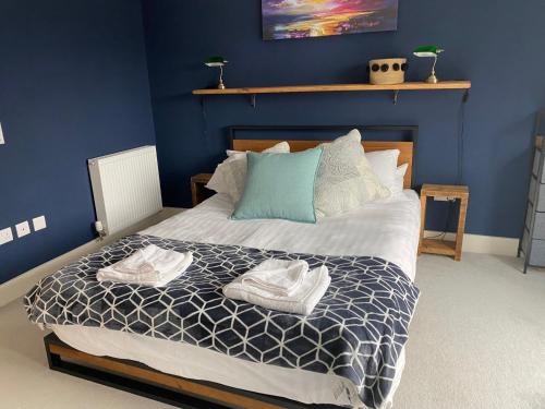 邦尼里格Modern Home Near Edinburgh City的一间卧室配有一张床,上面有两条毛巾