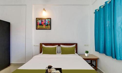 莫尔吉姆FabExpress Aqua Vista的一间卧室配有一张带绿色枕头的大床