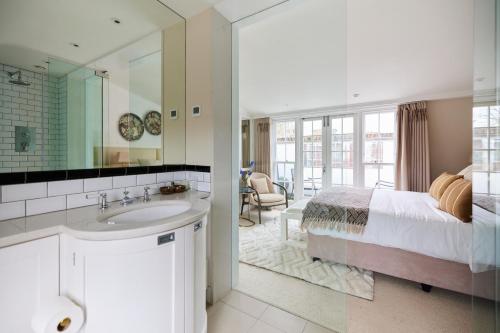 伦敦The St. Lukes Garden Place - Spacious 4BDR House with Garden and Terrace的一间带水槽的浴室和一张带镜子的床