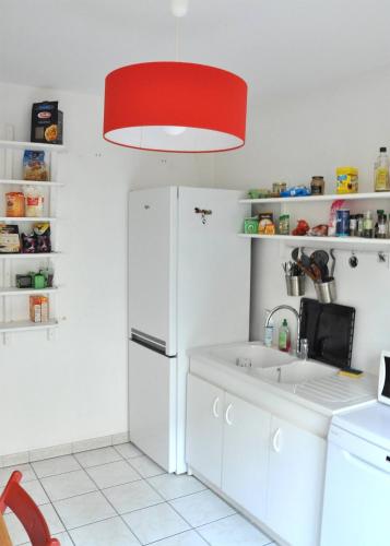 里昂Le Vendôme的厨房配有白色冰箱和红灯。