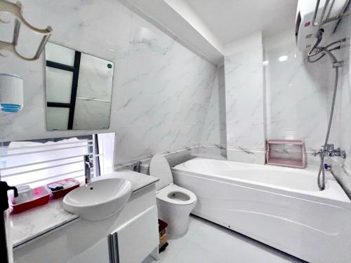 海防Daisy homestay & apartment的浴室配有白色浴缸、卫生间和水槽。