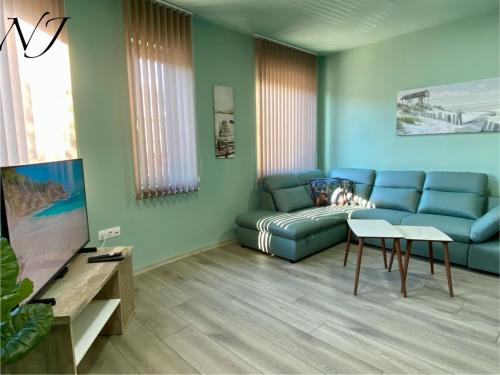 瓦尔纳NJ Luxury rooms and suites的客厅配有蓝色的沙发和电视