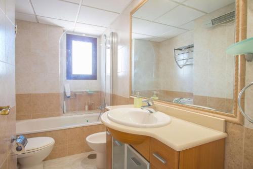 卡尔佩Apartamento Coral Beach - PlusHolidays的一间带水槽、卫生间和镜子的浴室