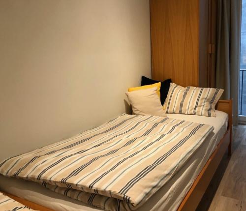克诺克－海斯特appartement DE WATERLIJN的一张带条纹床单和枕头的床