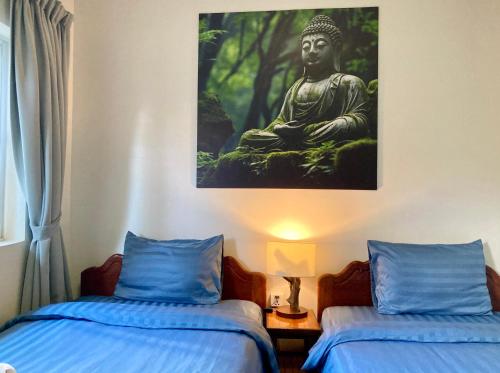 暹粒Lotus Haven Villa的一间设有两张床的房间和一幅佛陀画