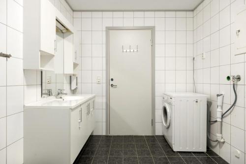 弗洛姆Flåm Station Apartments的白色的浴室设有水槽和洗衣机。