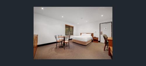 格拉德斯通格拉德斯通公寓式酒店的一间卧室配有一张床、一张桌子和一张书桌