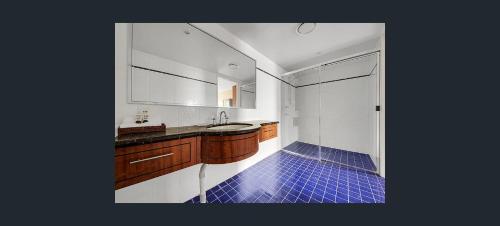 格拉德斯通格拉德斯通公寓式酒店的设有带水槽和蓝色瓷砖地板的浴室