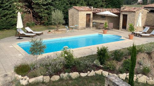 加尔加斯Le Mas de Caroline的庭院内的游泳池配有椅子和遮阳伞