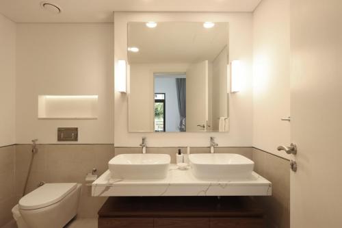 迪拜Livbnb - 2BR close to Souk Mall and Burj Al Arab的浴室设有2个水槽、卫生间和镜子。