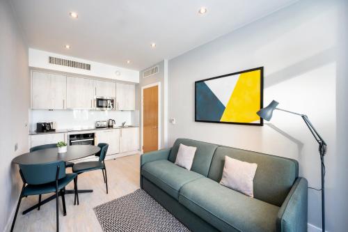 利物浦Staycity Aparthotels Liverpool Waterfront的客厅配有沙发和桌子