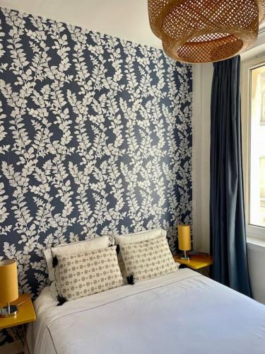 滨海图维列Appartement à côté de la plage avec balcon filant的一间卧室配有一张蓝色和白色壁纸的床