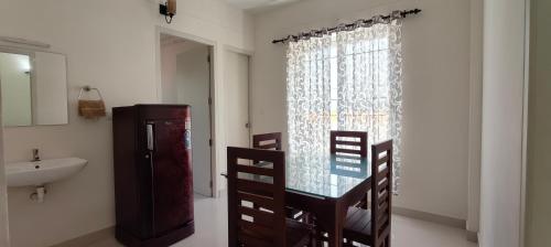 特里凡得琅Hobiz Serviced Apartments Chalakuzhy Nr Medical College Trivandrum的一间带玻璃桌和水槽的浴室