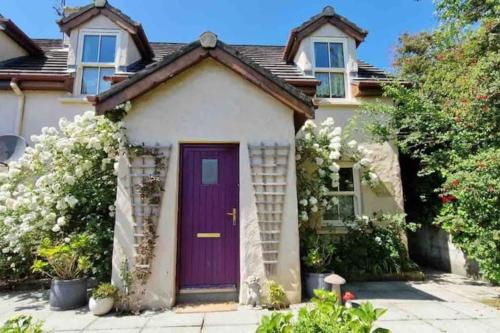 丁格尔Orchard Cottage的紫色门的房子