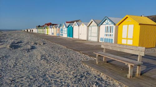 滨海卡约gite repos et tranquillité G的海滩上一排色彩缤纷的海滩小屋