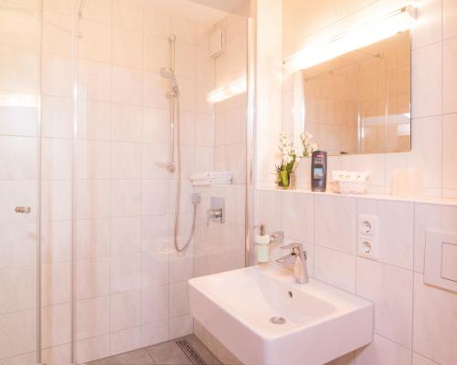 奥伯斯特多夫加尼里吉纳酒店的白色的浴室设有水槽和淋浴。