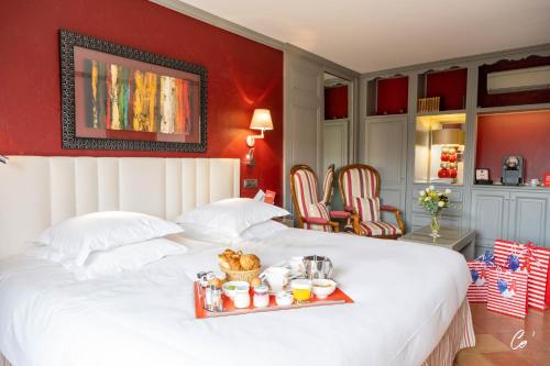沃纳斯乔治布兰克酒店&Spa的一张大白色的床,上面有盘子的食物