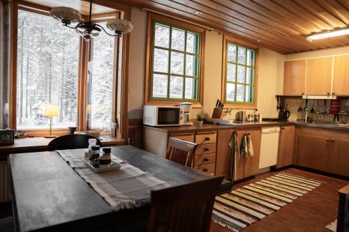 上托尔内奥Bed & Breakfast Willa Armas的厨房配有桌子和一些窗户