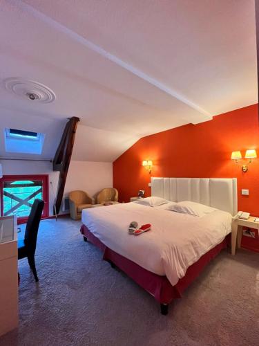 沃纳斯Les Saules Parc & Spa - Teritoria的一间卧室配有一张带橙色墙壁的大床