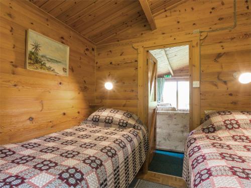 阿多奈格 2 Bed in Ardeonaig CA351的木墙客房的两张床