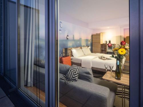 维也纳维也纳诺富特酒店的酒店客房带床、沙发以及房间