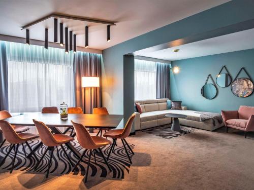 卡托维兹卡托维兹中枢诺富特酒店的客厅配有桌椅和沙发
