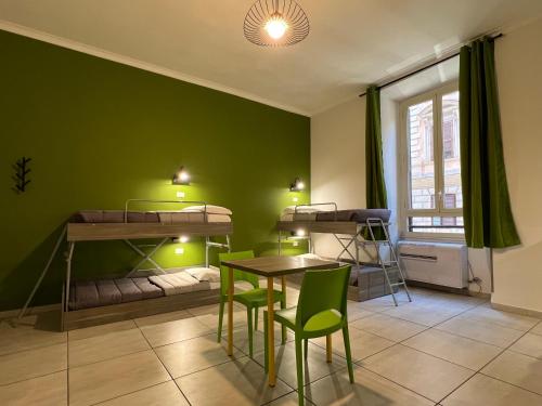 罗马罗马帕拉迪尼旅舍的客房设有四张双层床和一张桌子及椅子。