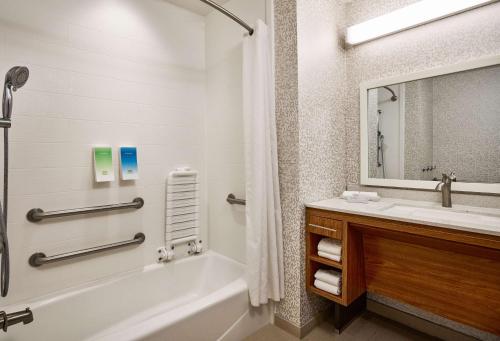 圣安东尼奥德州圣安东尼奥机场希尔顿欣庭套房酒店的带浴缸、水槽和镜子的浴室