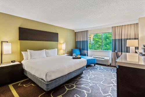 夏洛特Doubletree by Hilton Charlotte Uptown的酒店客房带大床和蓝椅