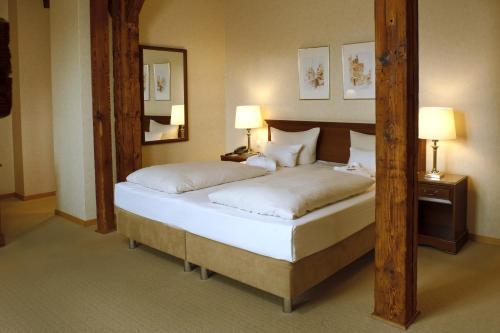 吕讷堡Bergström Hotel Lüneburg的一间卧室配有一张带白色床单的大床