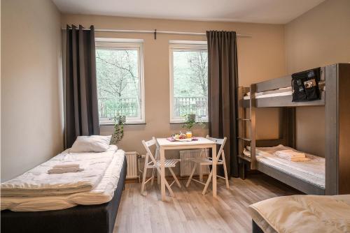 哥德堡Göteborgs Bed & Breakfast的客房设有两张床、一张桌子和一张双层床。