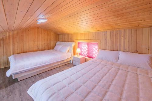 顺天市Suncheonbay Reed Field Pension的木制客房内的一间卧室配有两张床