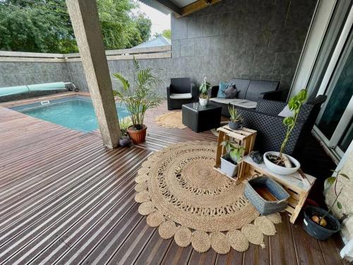 圣若瑟La villa Loca Reunion的庭院设有1个带桌子、1张沙发和1张桌子的游泳池。
