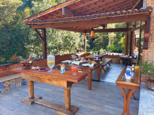 卢米亚Pousada Som de Lumiar的庭院设有木桌和凉亭。