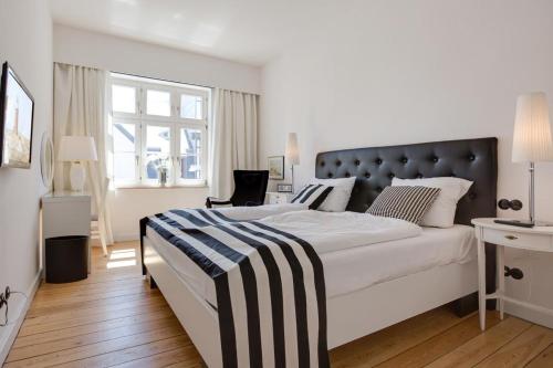 韦斯特兰Die Schlosserei的一间卧室配有一张白色大床和黑色床头板