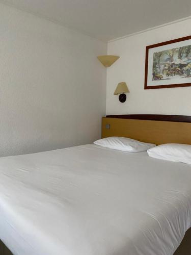 卡奥尔钟楼卡奥尔酒店的卧室配有2张白色的床,墙上挂着一幅画