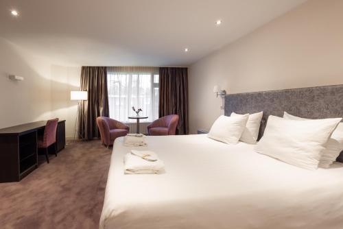 奥斯特韦克罗瑟普庄园的酒店客房设有一张白色大床和一张书桌