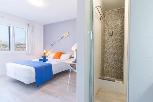 GuazaHostel Neon Tenerife的一间卧室设有一张床和一个玻璃门