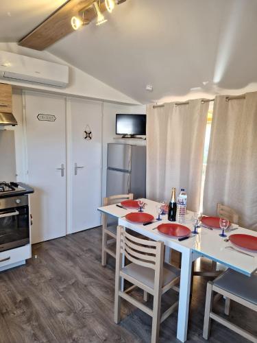 鲁西隆地区卡内Mobile home Chic的厨房配有桌椅和冰箱。