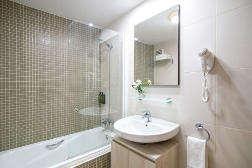 塞维利亚塞维利亚皮埃尔假日酒店的一间带水槽、浴缸和镜子的浴室