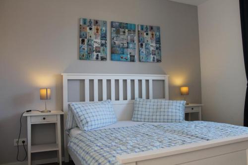 博恩Ferienwohnung Blue in Born的一间卧室配有一张带2个床头柜和2盏灯的床。